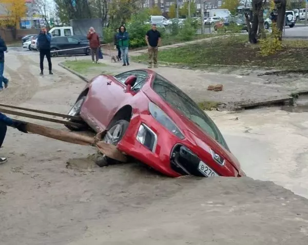 Фото к материалу: В Ростове на улице Вересаева легковушка эпично ушла под землю